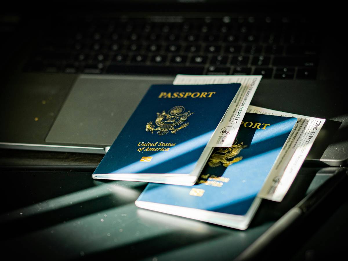 contract worker travel insurance showing a freelancer checking policy details on laptop at airport